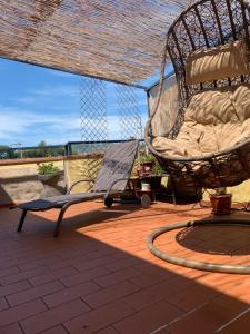 a rocking chair and a swing on a patio at attico19 in Montecatini Terme