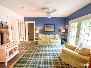 a living room with a couch and a fireplace at West Hill Farmhouse in Warren