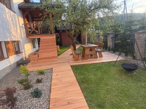 a wooden deck with a table and chairs in a yard at Apartament Florynka in Florynka
