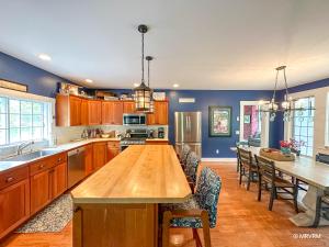 a large kitchen with a wooden table and chairs at West Hill Farmhouse in Warren
