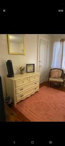 a room with a dresser with a mirror and a chair at NH room rental in Akron