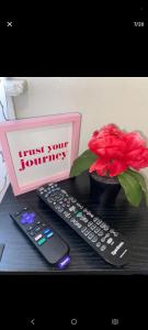 a desk with two remote controls and a red flower at NH room rental in Akron