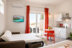 a small room with a bed and a kitchen at RestHouse The Village in Nardò