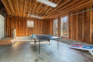 a ping pong table in a room with wooden walls at Firepit Game Room Seclusion and More in Locust Lakes Village