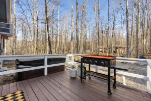 a grill on a deck with trees in the background at Firepit Game Room Seclusion and More in Locust Lakes Village