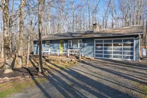 a blue house with a garage in the woods at Firepit Game Room Seclusion and More in Locust Lakes Village +74 photos