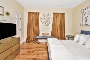 a bedroom with a bed and a flat screen tv at Comfort Stay in Boston