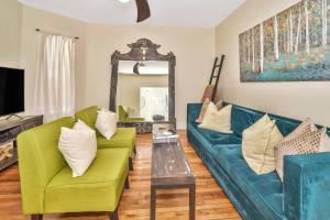 a living room with a green couch and a mirror at Comfort Stay in Boston