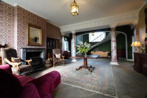 a living room with a couch and a table and a fireplace at Rockfield House in Kells