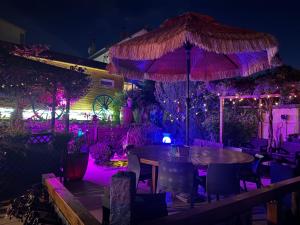 a restaurant with a table and an umbrella at night at La Petalerie Appartements d'hôtes in Épernay