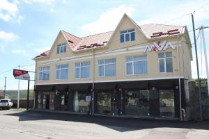 a large building with a max store on the street at Miva in Qusar