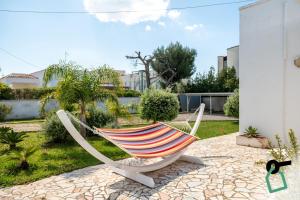 a hammock sitting on a patio in a yard at Hotiday Torre Lapillo Centro in Torre Lapillo