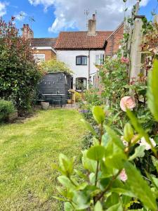 a garden with a bench and a house at Holly Cottage in Edwinstowe