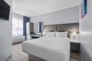 a hotel room with a large white bed and a window at Travelodge by Wyndham Montreal Centre in Montreal +72 photos