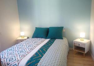 a bedroom with a bed with two nightstands and two lamps at La Pause Jardaise in Jard-sur-Mer