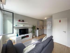 a living room with a blue couch and a tv at Allegro Patio House in Porto