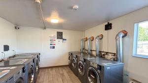 a laundry room with three washing machines and a window at Studio 6 Greenville, SC in Greenville