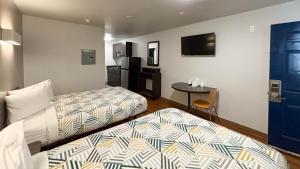 a hotel room with two beds and a table at Studio 6 Greenville, SC in Greenville