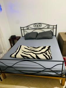 a bed with a zebra blanket and pillows on it at Omrane in Tunis