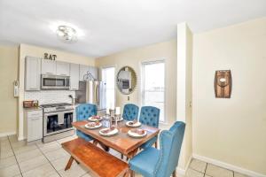 a kitchen and dining room with a wooden table and blue chairs at Comfort Stay in Boston