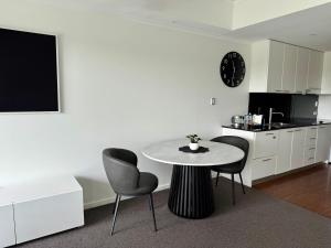 a kitchen with a table and chairs in a room at HAVEN by the Sea in Mandurah