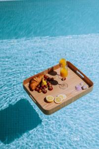 a tray of food and a glass of orange juice and a tray of bread at Plethora Luxury Suites in Rodhiá