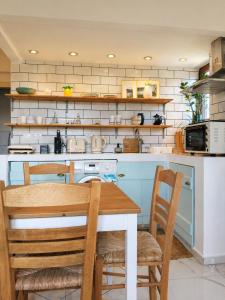a kitchen with a table and two chairs and a stove at Greek Blue Apartment! small apartment, small bathroom in Plakias
