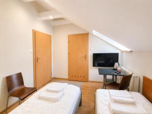 a room with two beds and a table and a chair at Pokoje Noclegowe Sierpów in Sierpów