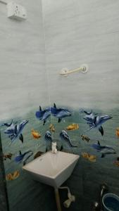 a painting of dolphins in the water next to a sink at OM Homestay in Dwarka