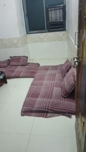 two beds in a room with purple sheets and pillows at OM Homestay in Dwarka