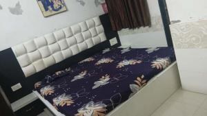 a bed with a purple comforter on it at OM Homestay in Dwarka