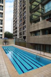 a large swimming pool in front of a building at Promenade Pancetti Belo Horizonte in Belo Horizonte