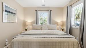 a bedroom with a large bed with two windows at Treehouse at BootLegger Cove in Bluffton