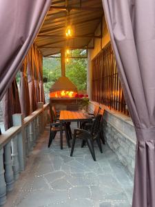 an outdoor patio with a table and chairs and a fireplace at Guest House in Halidzor