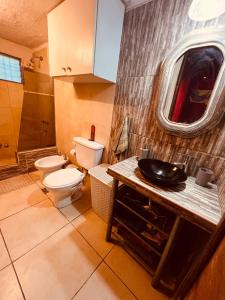 a bathroom with a toilet and a sink at Hospedaje San Luis Sierras in Juana Koslay  +34 photos