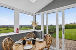 a dining room with a table and chairs and windows at 2 Bed in Taunton oc-conco in West Monkton