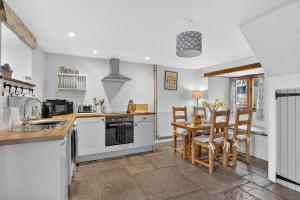 a kitchen with white cabinets and a table and chairs at 2 Bed in Taunton oc-conco in West Monkton +9 photos
