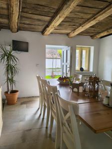 a dining room with a wooden table and chairs at Casa Via Viscri in Buneşti