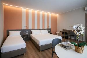 a hotel room with two beds and a table at CA' San Cristoforo Apartments & Suites in Milan +55 photos