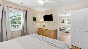 a bedroom with a bed and a desk and a television at Treehouse at BootLegger Cove in Bluffton
