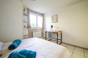 a bedroom with a bed with a desk and a window at Cocon chatillonnais in Châtillon-sur-Chalaronne