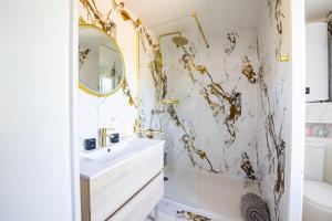 a bathroom with a white sink and a mirror at Cocon chatillonnais in Châtillon-sur-Chalaronne +16 photos