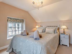 a bedroom with a large bed with a chandelier at 3 Bed in Swanage oc-ic098 in Swanage