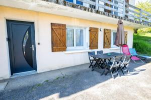 a table with chairs and an umbrella next to a building at Cocon chatillonnais in Châtillon-sur-Chalaronne
