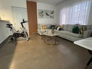 a living room with a couch and a exercise bike at Calm Stay Monte Plata in Monte Plata