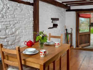 a wooden table with plates and cups and flowers on it at 1 Bed in Brecon oc-bn336 in Talgarth