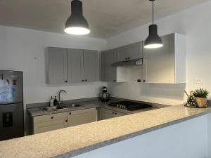 a kitchen with white cabinets and a counter top at Calm Stay Monte Plata in Monte Plata