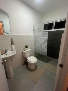 a bathroom with a toilet and a sink and a shower at Calm Stay Monte Plata in Monte Plata