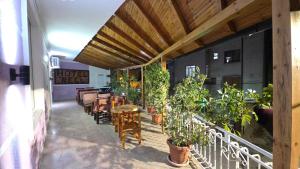 a balcony with tables and chairs and potted plants at Hotel Reci in Peshkopi