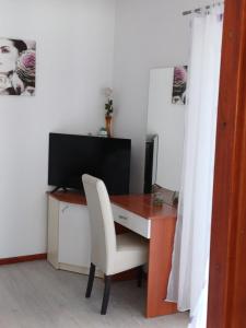 a desk with a white chair and a television at Apartments Jure Miljak in Podstrana